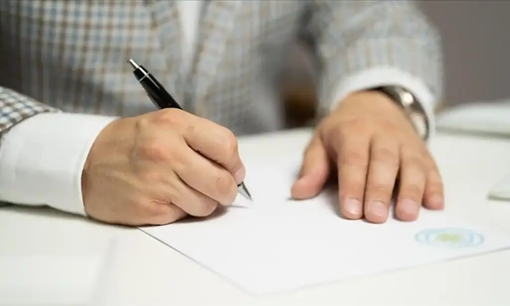 elinde dolma kalemle adam