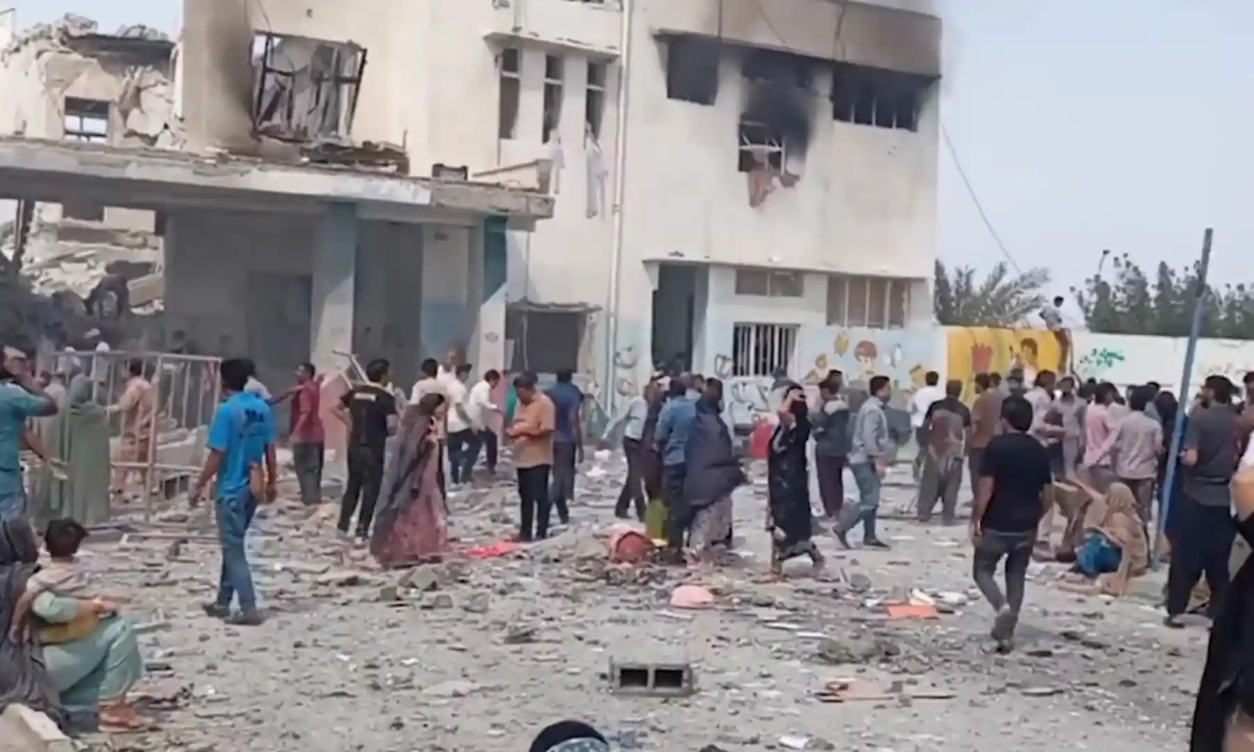 yıkılmış okul çevresinde insanlar