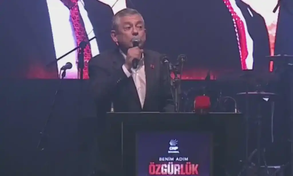 Özgür Özel elinde ve önünde mikrofonla