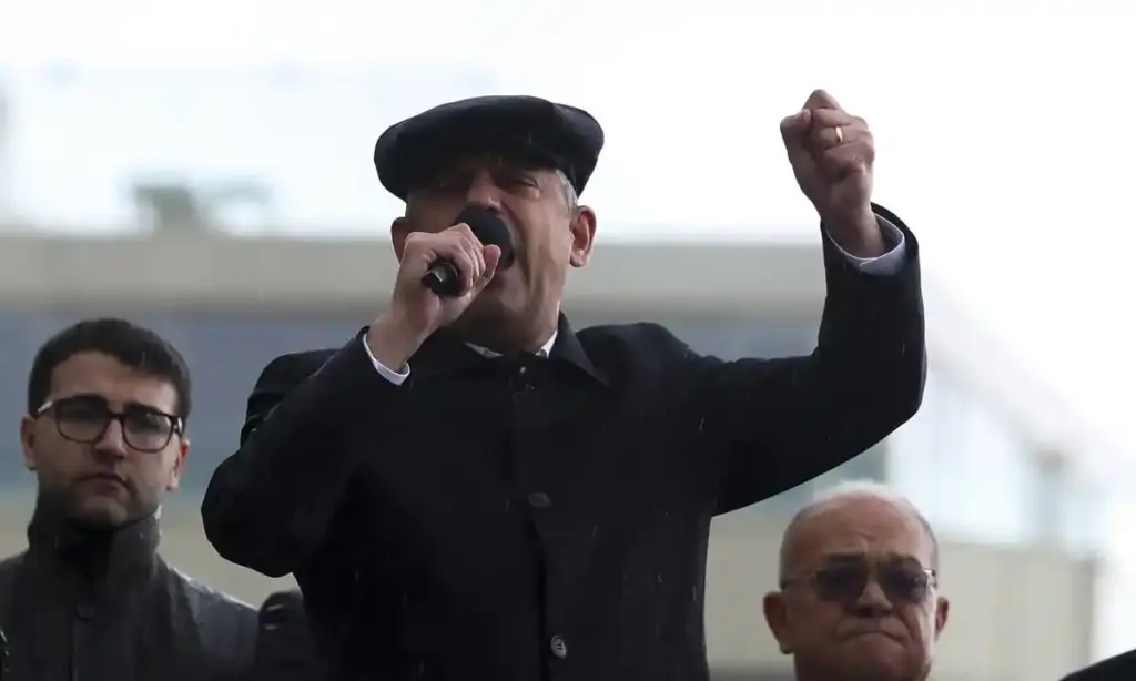 Özgür Özel elinde mikrofon ve başında kasket ile